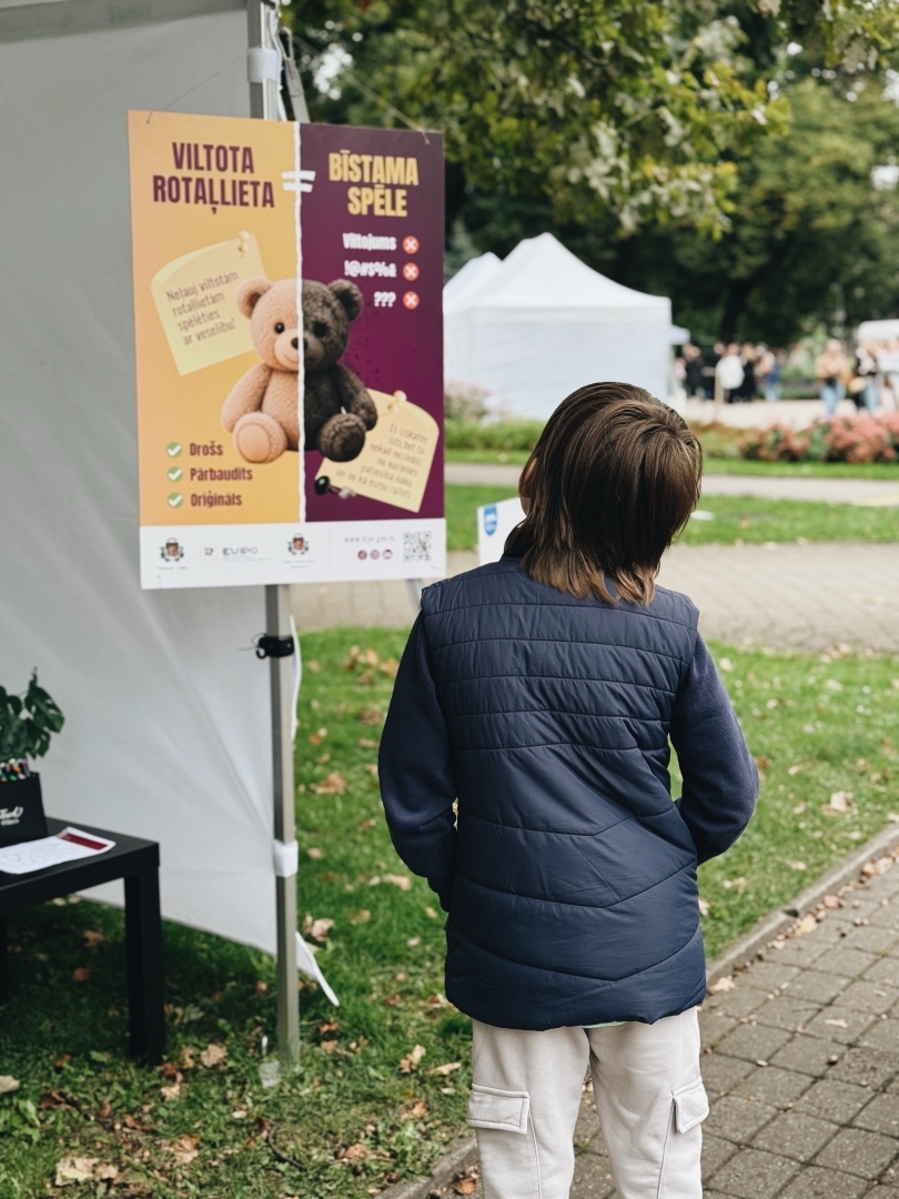 Bērns skatās uz mūsu plakātu par viltotām rotaļlietām