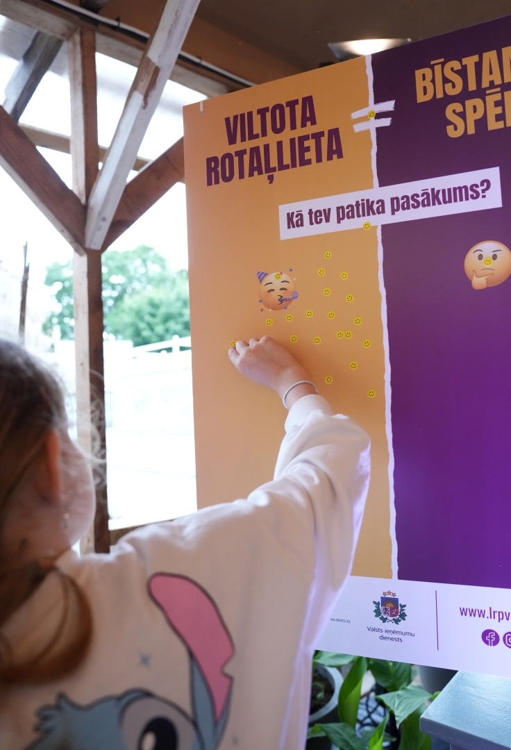 Apmeklētāji līmējot novērtējuma uzlīmes par pasākumu