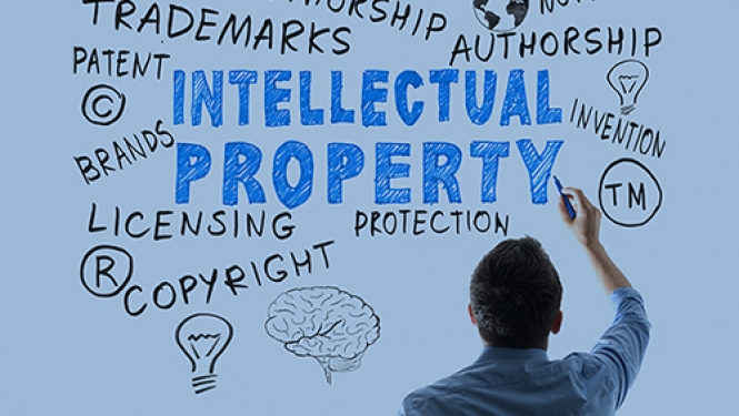 Attēls ar vīrieti, kurš raksta tekstu angļu valodā: Intelectual property. 
