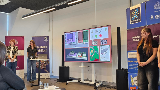 Komandas "Sārtie marcipāni" dalībnieces prezentē spēli "Zīmolu slazdi"