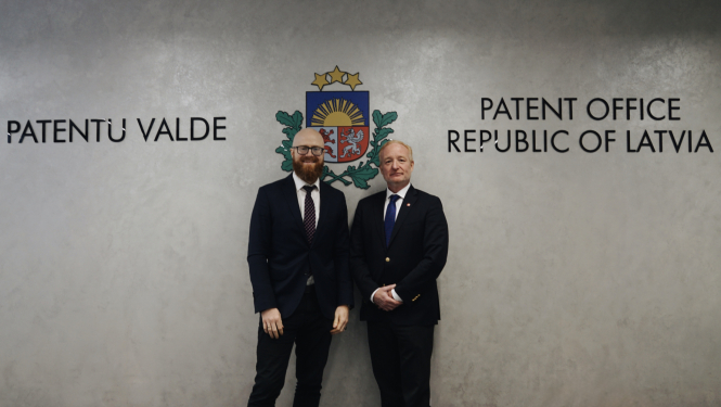 Agris Batakauskis un Antonio Campinoss oficiālā bildē pie pelēkas sienas ar uzrakstu Patentu valde