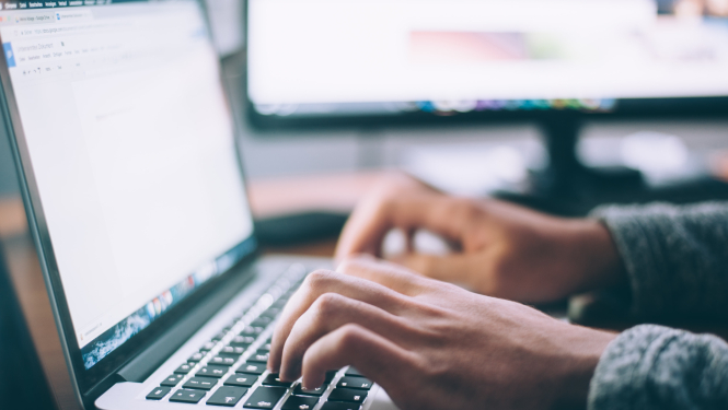 Cilvēks izmanto datoru, lai ievadīt informāciju