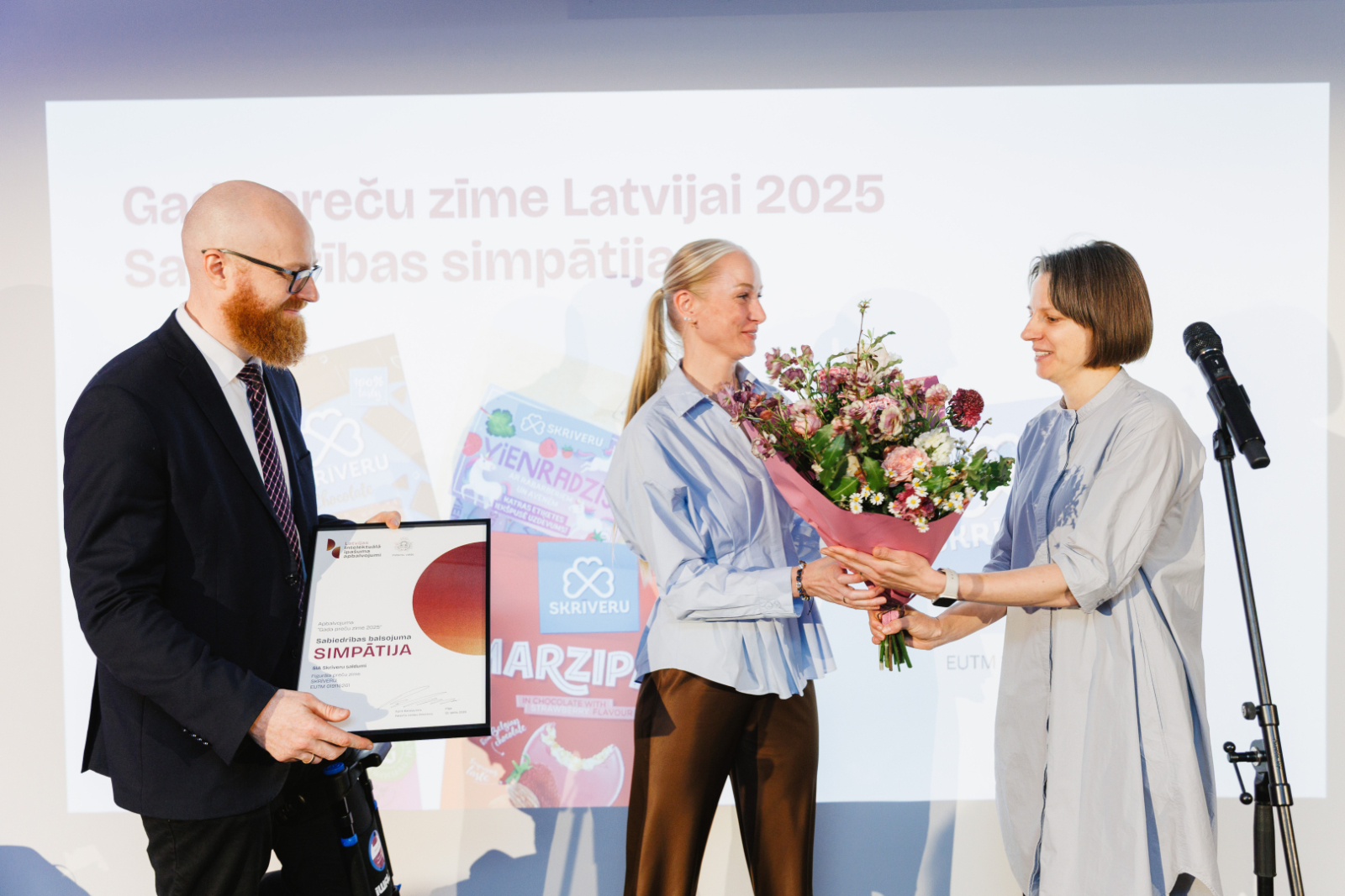 LSM.lv interneta daļas vadītāja Marta Cerava pasniedz ziedus uzņēmuma "Skrīveru saldumi" valdes loceklei Sintijai Bredikai