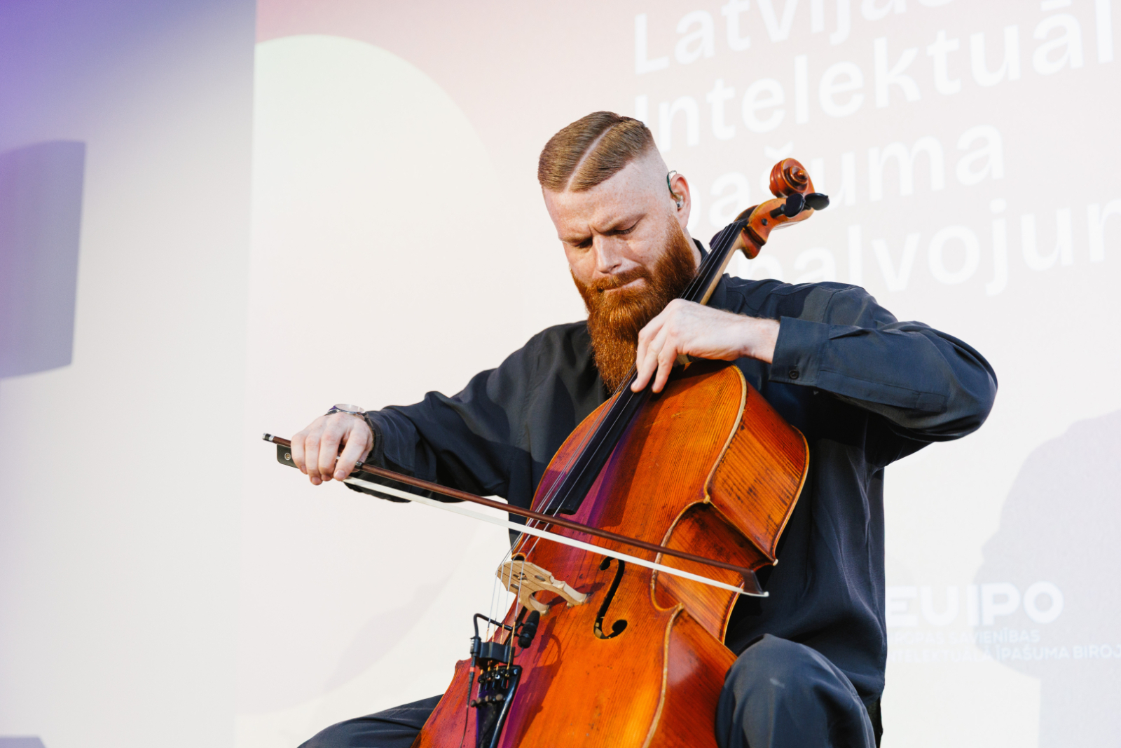 Mākslinieks M.Radzēvičs spēlējot čellu