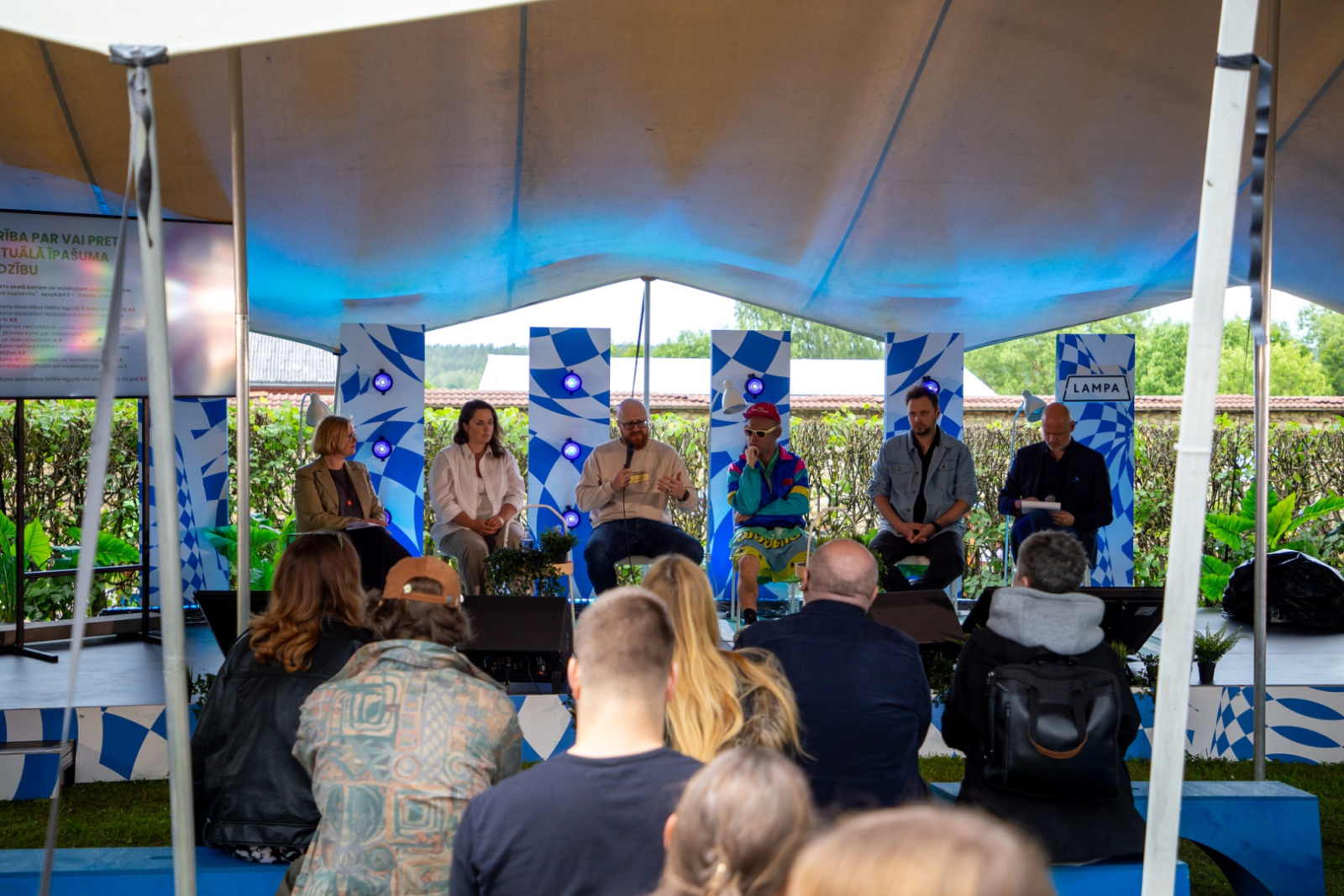 Sarunu festivālā "Lampa" notiek diskusija par intelektuālā īpašuma jautājumiem. Uz skatuves piecu dalībnieku panelī ar mikrofonu runā Patentu valdes direktors Agris Batalauskis, blakus sēž citi eksperti un diskusijas vadītājs