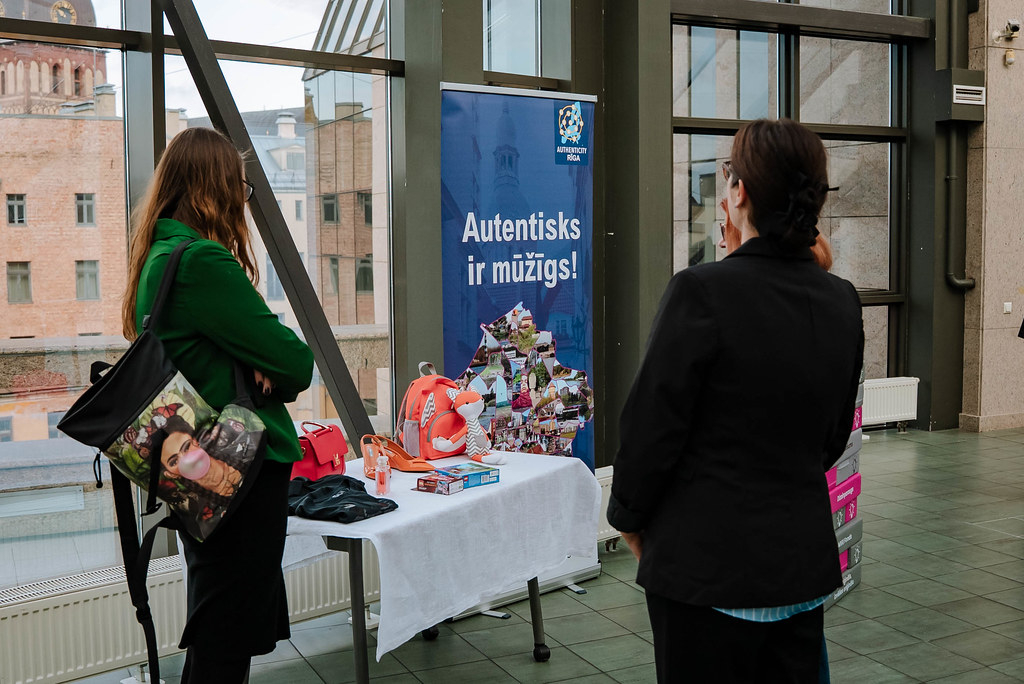 Apmeklētāji apskatot viltojumus