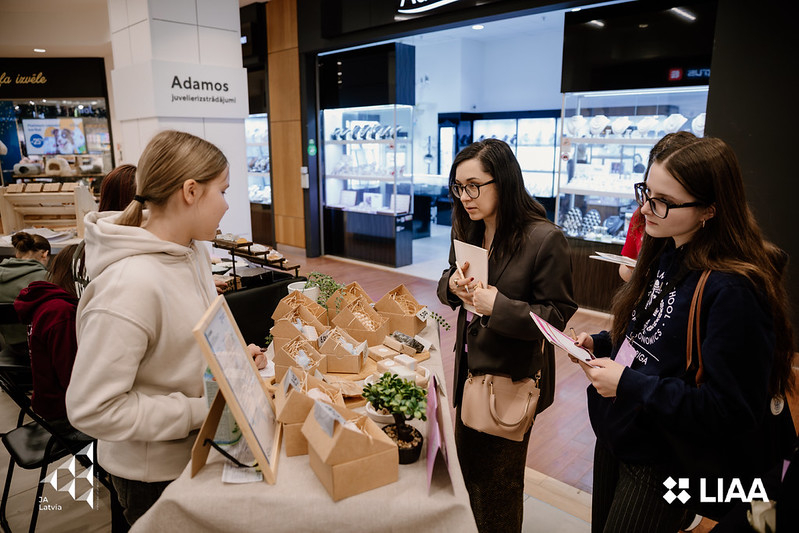 Dalībnieku stends un Attīstības un starptautiskās sadarbības departamenta direktore I. Grava veicot žūrijas darbu