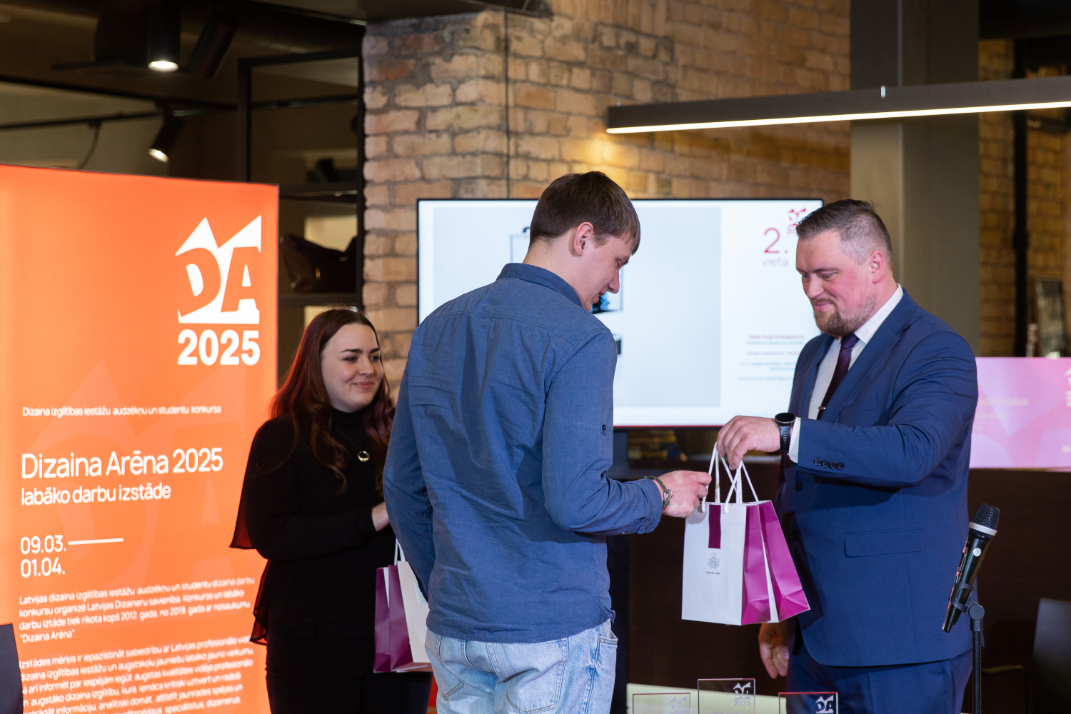 Patentu valdes direktora vietnieks Ē.Rēķis pasniedz balvu Lietu dizains skolas 2.vietas ieguvējam R.R.Kristapsonam