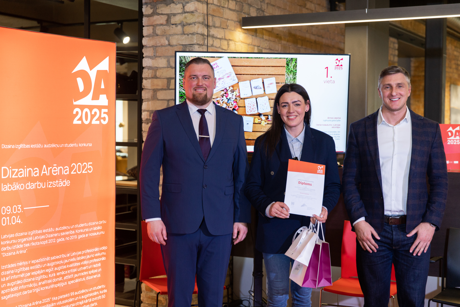 Patentu valdes direktora vietnieks Ē.Rēķis un Saziņas dizaina Augstskolas kategorijas 1.vietas ieguvēja A.Liepiņa