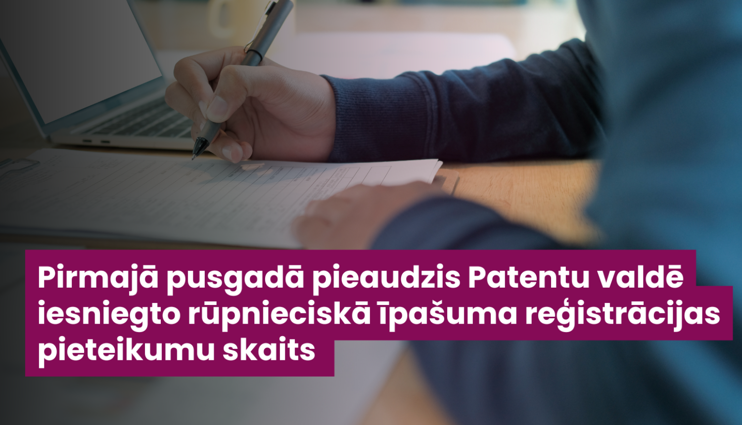 Ilustratīvs attēls ar darba virsmu, datoru, anketu un cilvēka rokām, kas tur pildspalvu