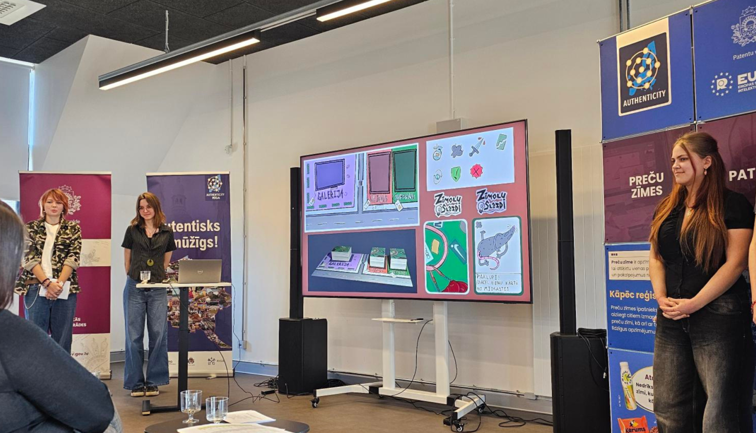 Komandas "Sārtie marcipāni" dalībnieces prezentē spēli "Zīmolu slazdi"